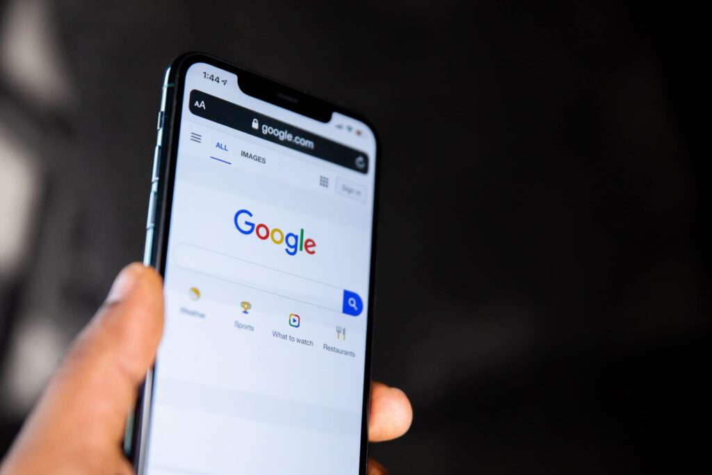 Hand holding phone with Google site pulled up